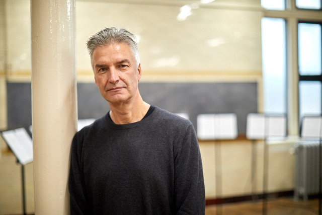 A portrait of Nic, who has white hair and stands facing the camera